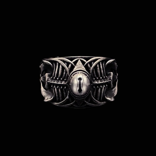 Close-up of Sin-Bearer's Gaze Ring, oxidized silver Ram skull design with central yellow cat-eye stone.