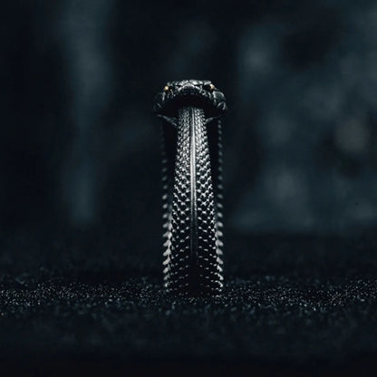 Close-up of the snake's head on the Fate Eclipse Ring, focusing on the intricate scales and the single, piercing yellow eye.