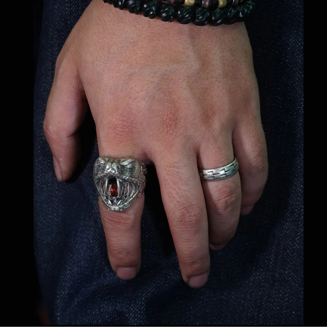 Men's oxidized silver snake ring, Fanged Resolve, with ruby gemstone for strength and transformation.
